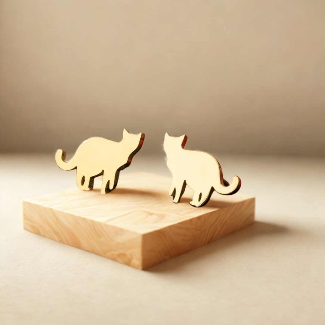 Cat-inspired stainless steel earrings shaped like playful cats displayed on a wooden block